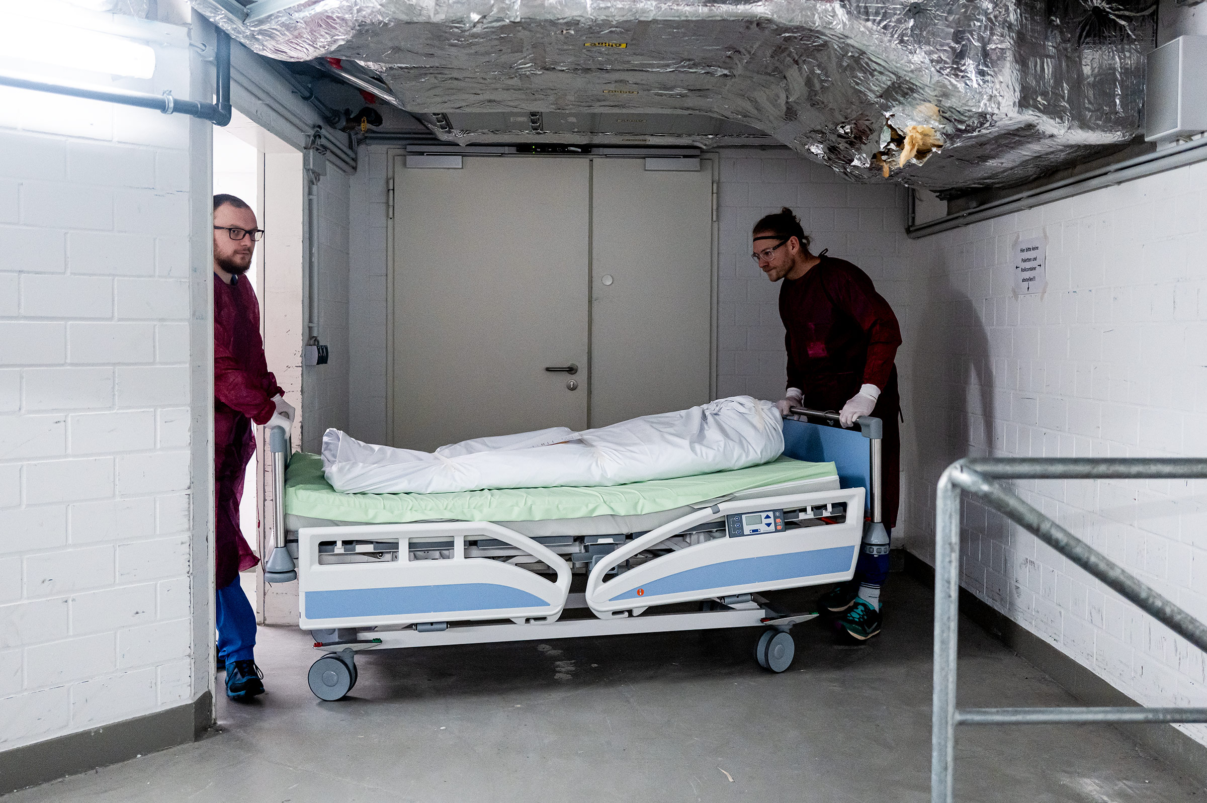 Mitarbeiter bringen einen verstorbenen Patienten in die Leichenhalle des Krankenhauses.