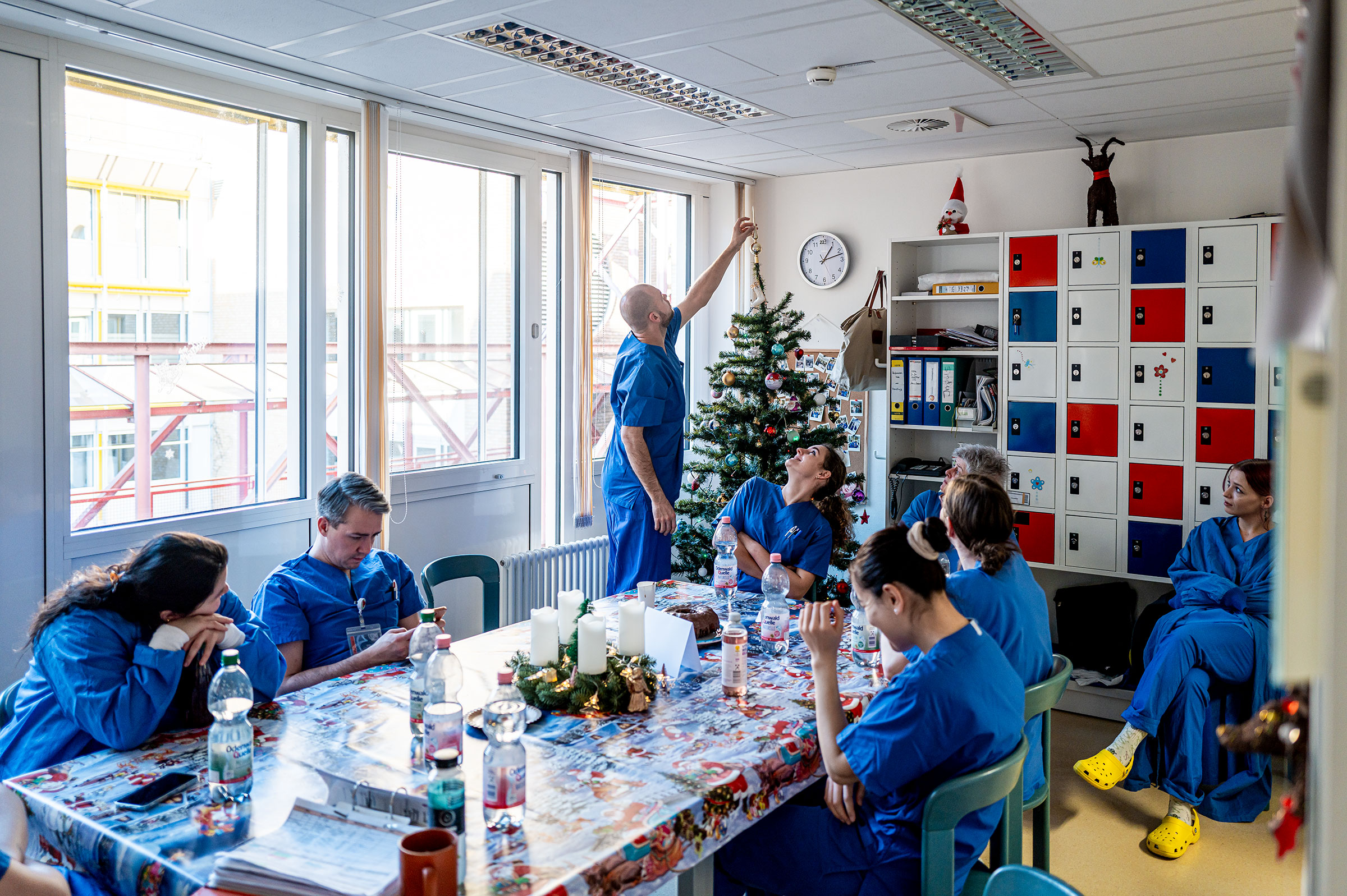 Im Aufenthaltsraum kommt das Team zusammen, ehe die Schicht beginnt. Eine der Mitarbeitenden bringt vor Schichtbeginn die Kolleginnen und Kollegen auf den aktuellen Stand.